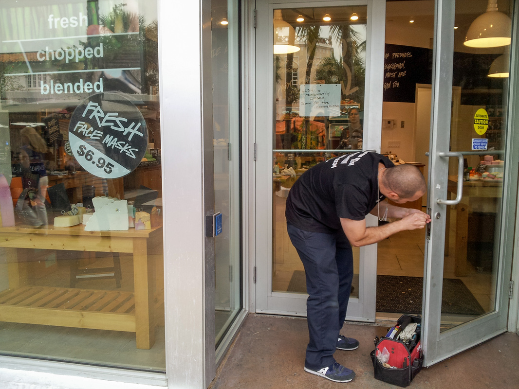 Xpress Locksmith technician opening a commercial glass door in Ontario